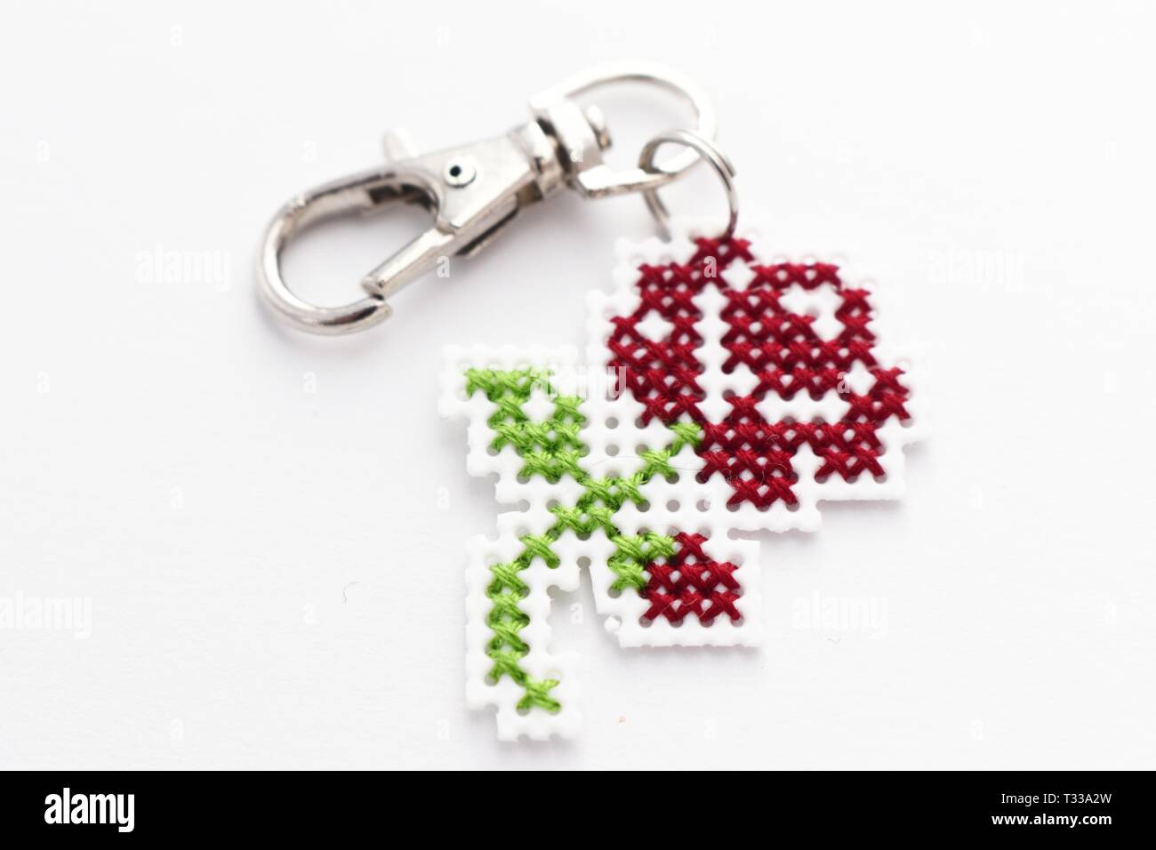 Handmade Cross Stitch Keychain Red Rose Stickerei auf weißem Kunststoff Leinwand Stockfoto