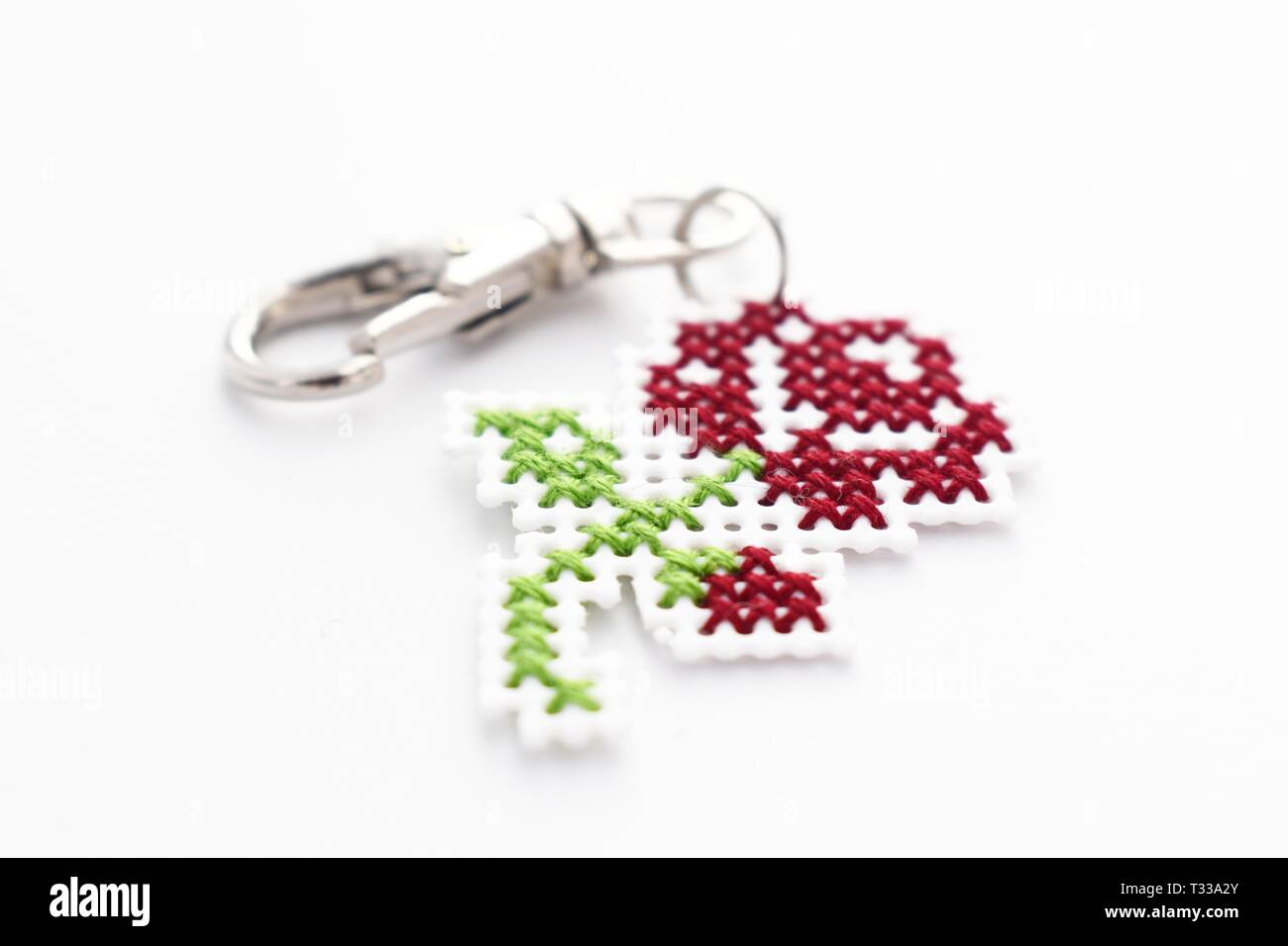 Handmade Cross Stitch Keychain Red Rose Stickerei auf weißem Kunststoff Leinwand Stockfoto