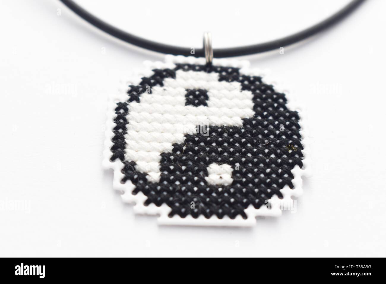 Handmade Cross Stitch Halskette Yin Yang Stickerei auf weißem Kunststoff Leinwand Stockfoto