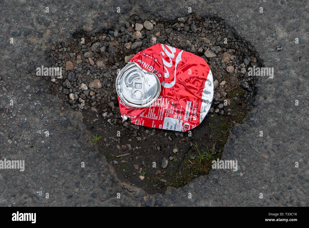 Stratford-upon-Avon, Warwickshire, England UK 23. März 2019 zerquetscht Coca Cola Dose und Schlagloch, die die Beschädigung der Welt durch große Corp durchgeführt Stockfoto
