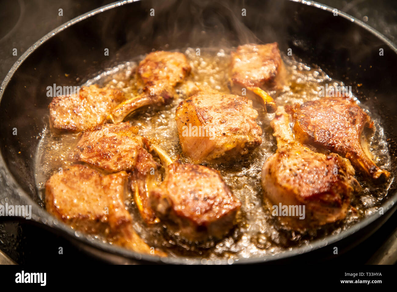 Kochen, Fleisch, Lamm Koteletts werden in einer Pfanne gebraten, Stockfoto