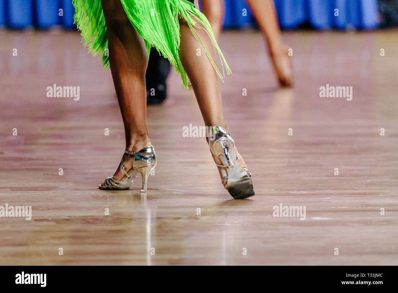 Beine Frau Tänzerin in Schuhe und grünen Kleid auf der Tanzfläche Stockfoto