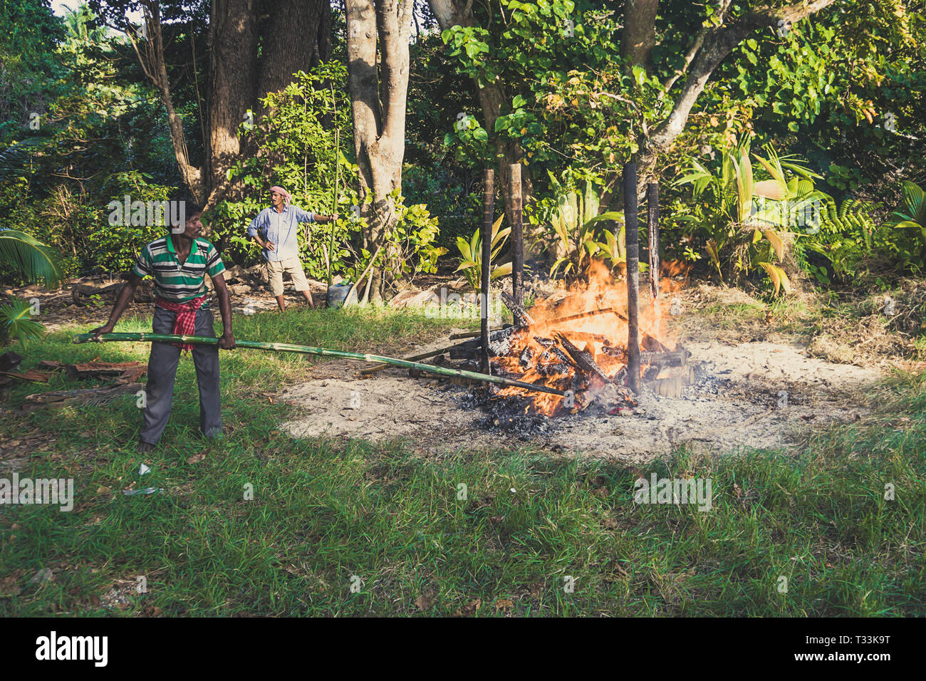 Prozess der Verbrennung in der Andamanen und Nikobaren. Hindu Traditionen. Die Inselbewohner des Verstorbenen auf dem Lagerfeuer am Ufer des t verbrannt Stockfoto