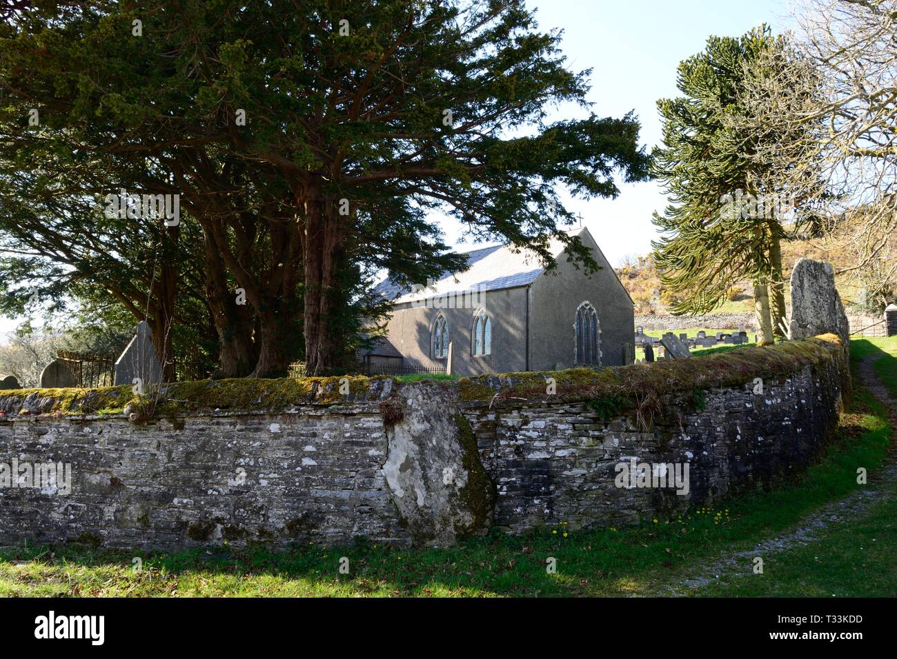 St Johns Kirche Ysbyty Cynfyn mit einem kreisförmigen Kirchhof mit einem Bronzezeit Steinkreis in die umgebende Mauer Cardiganshire Wales gebaut Stockfoto