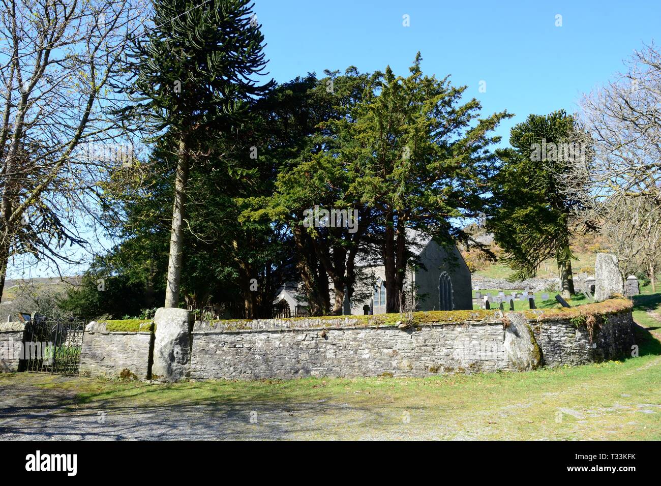 St Johns Kirche Ysbyty Cynfyn mit einem kreisförmigen Kirchhof mit einem Bronzezeit Steinkreis in die umgebende Mauer Cardiganshire Wales gebaut Stockfoto