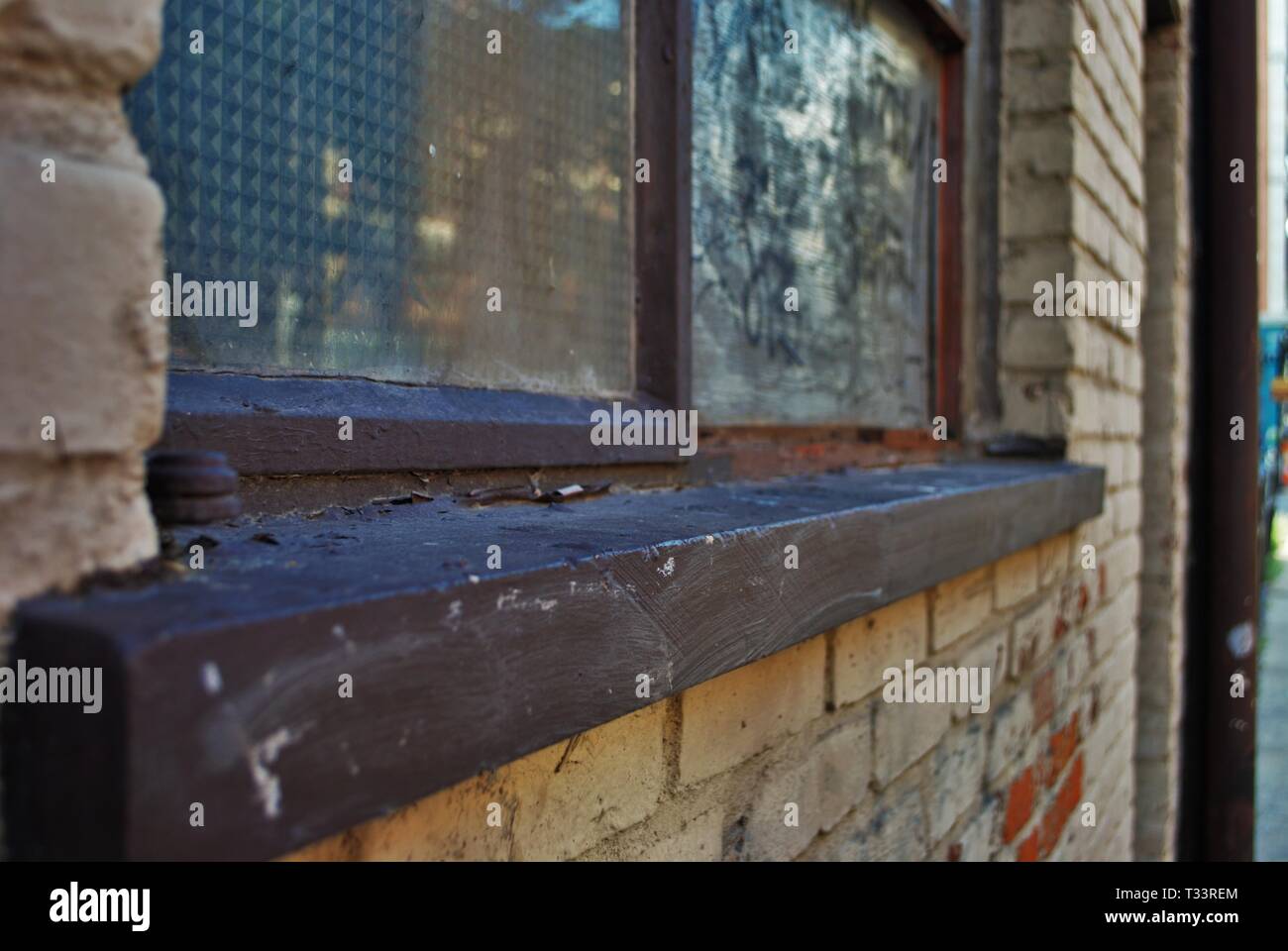 Nahaufnahme der ein zerbrochenes Fenster verschalt und Schweller mit abblätternder Farbe und Graffiti Stockfoto