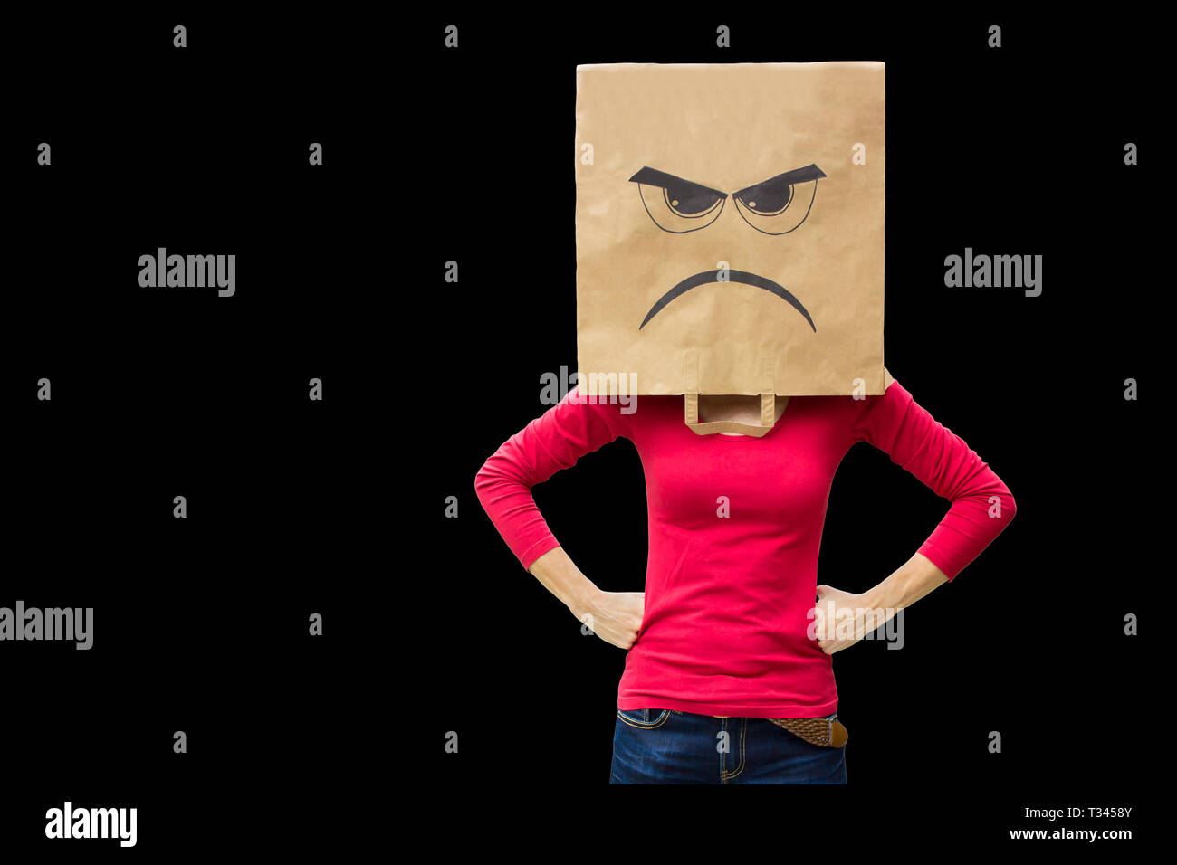 Wütende Frau trägt Papiertüte auf schwarzem Hintergrund Stockfoto