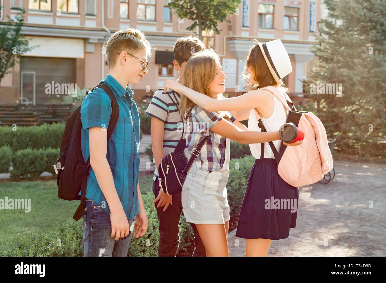 Lächelnd Freunde treffen Jugendliche in der Stadt, glückliche junge Leute Begrüßung, umarmen, fünf. Freundschaft und Personen Konzept. Stockfoto