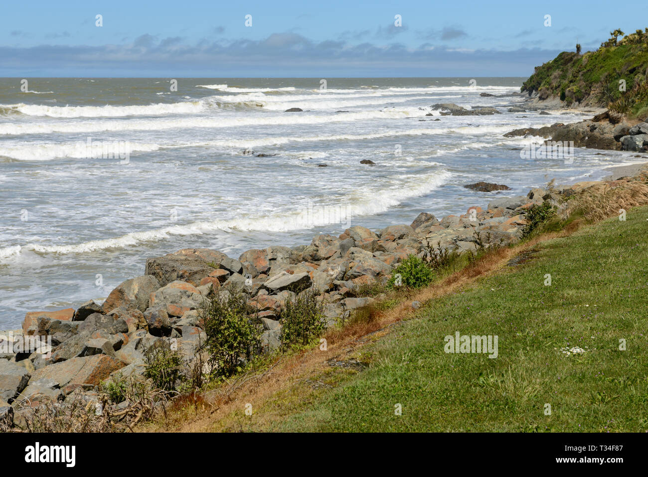 Große Wellen und riesige Felsbrocken auf den Pazifischen Ozean Küste in der Nähe der Kaka Point, Neuseeland Stockfoto