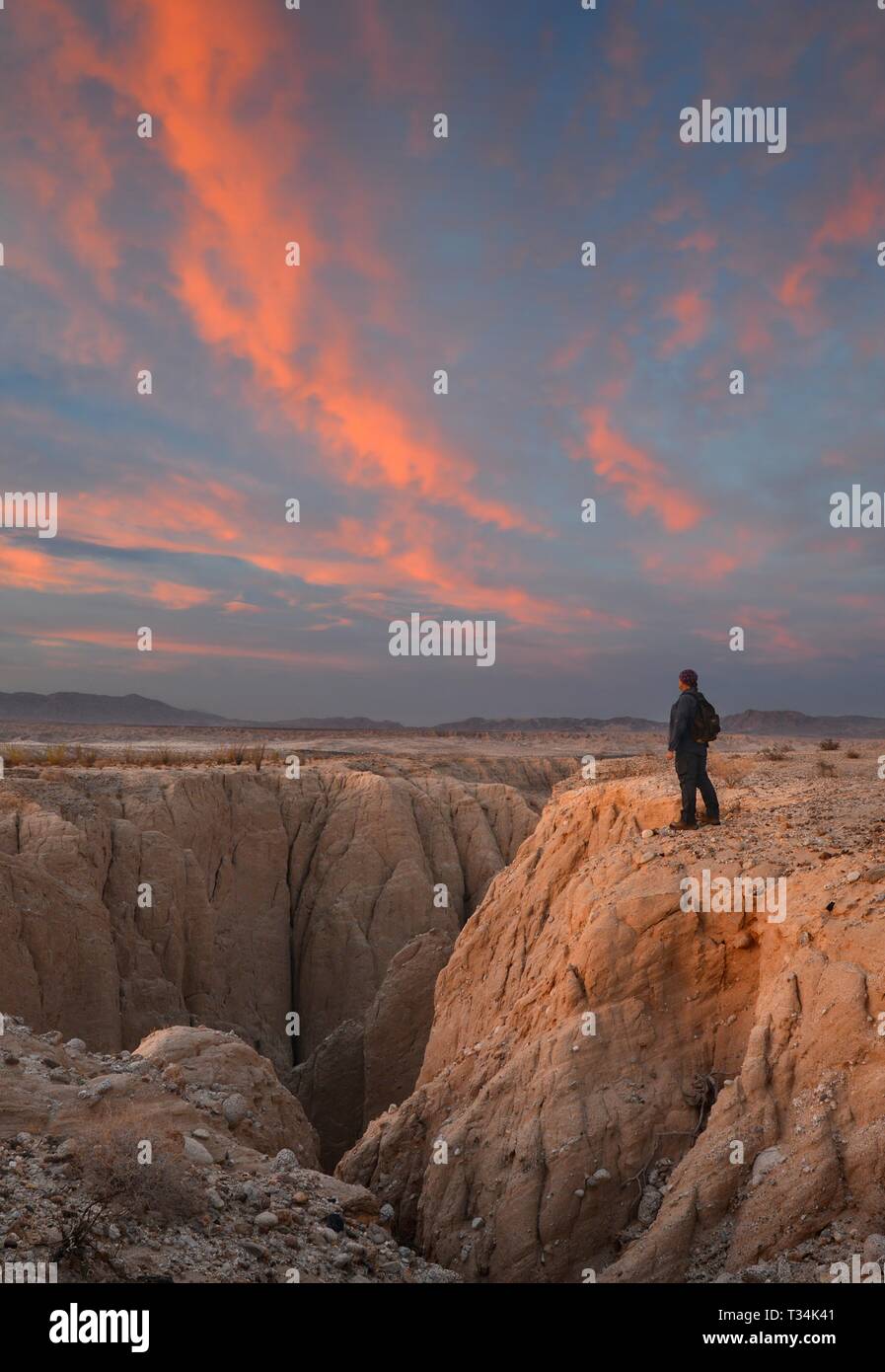 Mann am Rand des Canyon Sin Nombre Wanderweg bei Sonnenuntergang, Anza-Borrego Desert State Park, Kalifornien, USA Stockfoto