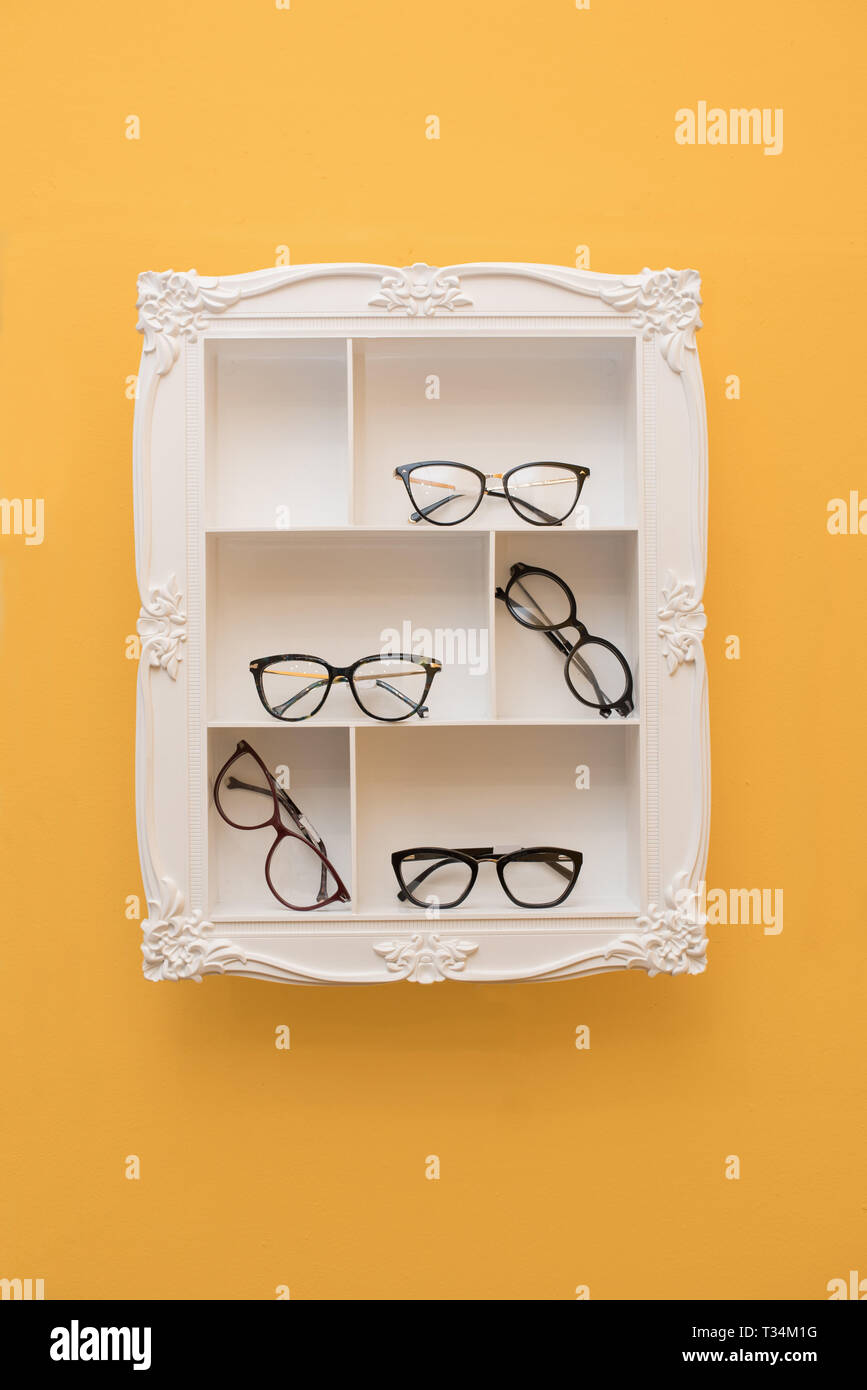 Brillen, die auf Regalen in einem Frame Stockfoto