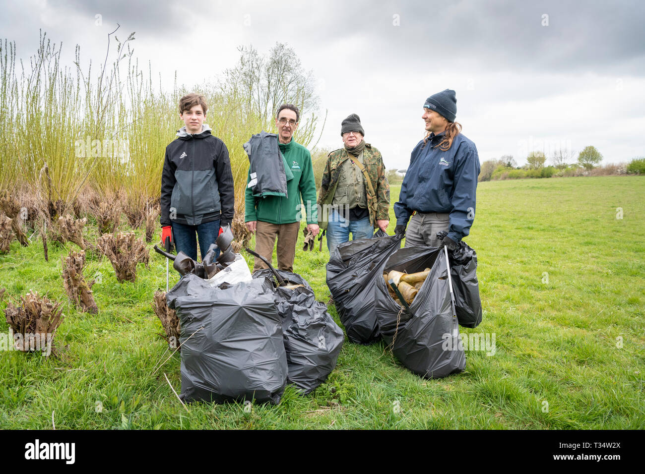 Lark Rise Farm, Barton Cambridgeshire UK 6. April 2019. Freiwillige clean up Wurf und alten Kunststoff verwendet, junge Bäume von einem willow Plantage als Teil der Großen Britischen Frühjahrsputz 2019 schützen. Die Freiwilligen helfen die Landschaft Restaurierung Vertrauen eine führende wildlife Landwirtschaft Nächstenliebe, die das Ereignis unter dem Dach der Halten Großbritannien ordentlich Initiative organisiert. Ziel ist es, 500.000 Menschen Wurf von Ihren lokalen Umgebungen zwischen 22. März und 23. April 2019 zu entfernen inspirieren. Credit: Julian Eales/Alamy leben Nachrichten Stockfoto