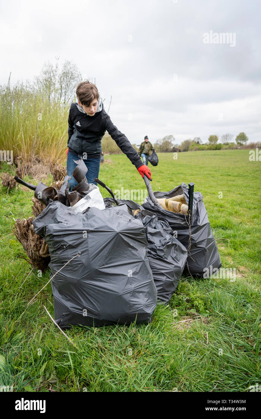 Lark Rise Farm, Barton Cambridgeshire UK 6. April 2019. Freiwillige clean up Wurf und alten Kunststoff verwendet, junge Bäume von einem willow Plantage als Teil der Großen Britischen Frühjahrsputz 2019 schützen. Die Freiwilligen helfen die Landschaft Restaurierung Vertrauen eine führende wildlife Landwirtschaft Nächstenliebe, die das Ereignis unter dem Dach der Halten Großbritannien ordentlich Initiative organisiert. Ziel ist es, 500.000 Menschen Wurf von Ihren lokalen Umgebungen zwischen 22. März und 23. April 2019 zu entfernen inspirieren. Credit: Julian Eales/Alamy leben Nachrichten Stockfoto