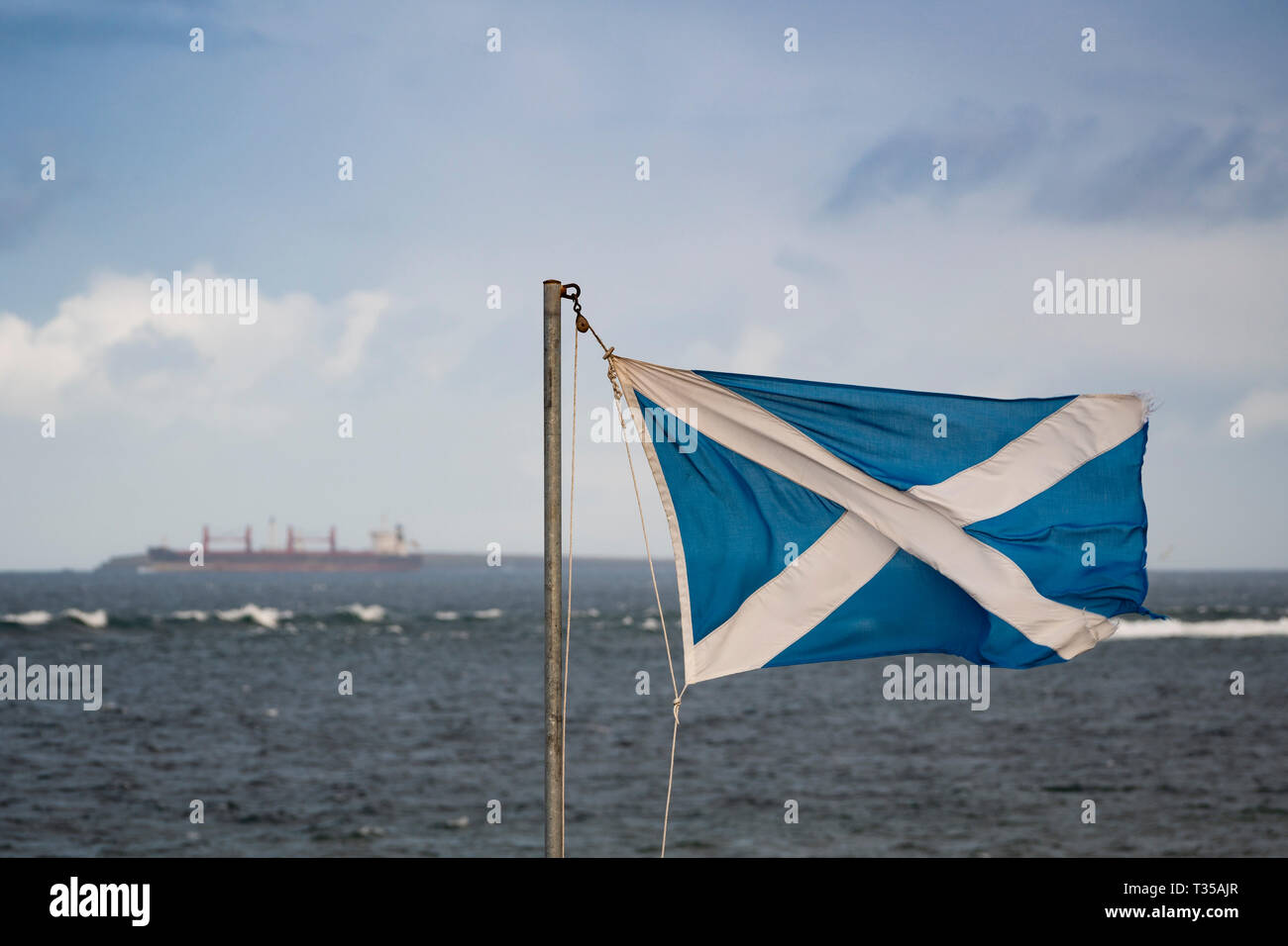 Schottische Flagge bei John O' Groats mit den Pentland Firth als Hintergrund. Stockfoto