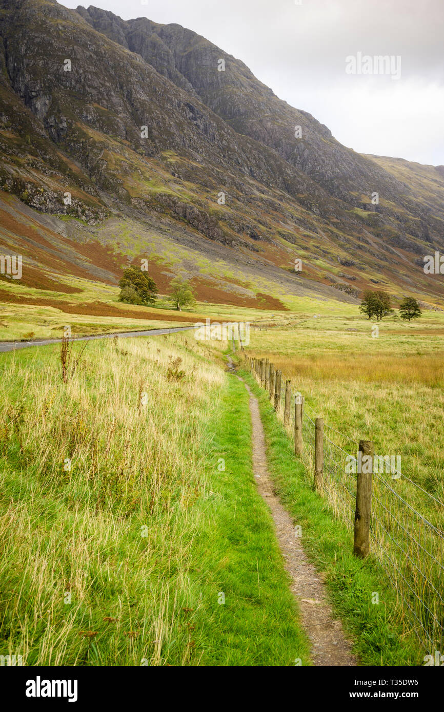 Sun Filterung durch Wolken, gezielt Teile des Tals in Glencoe, Schottland beleuchten. Stockfoto
