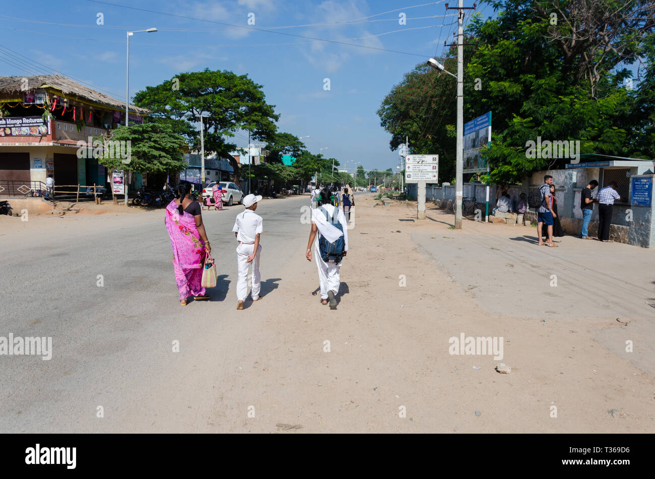 Zwei Schulkinder in Uniform zu Fuß am Straßenrand, in Kamalapura, Karnataka, Indien zur Schule Stockfoto