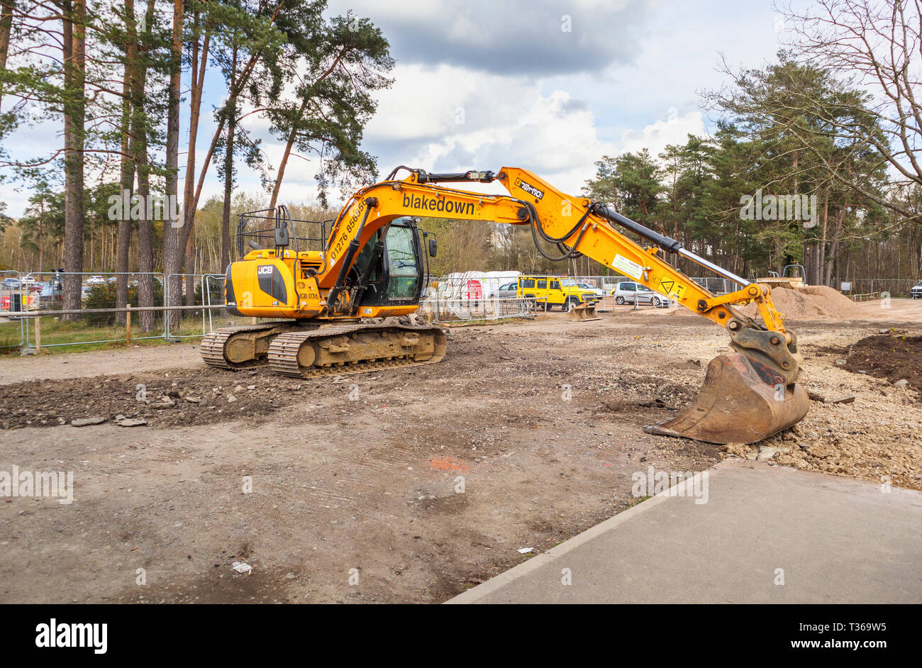 Gelb Caterpillar verfolgt JCB JS 130 LC schwerem Bagger Raupenbagger mit Schaufel Schaufel an der RHS Gärten, Wisley, Surrey, Großbritannien Stockfoto