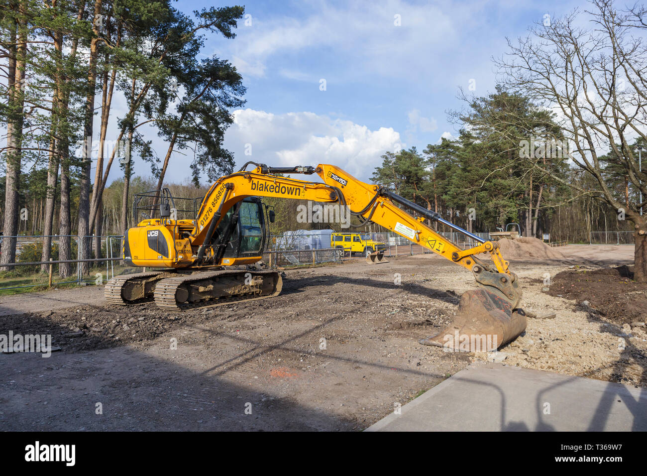 Gelb Caterpillar verfolgt JCB JS 130 LC schwerem Bagger Raupenbagger mit Schaufel Schaufel an der RHS Gärten, Wisley, Surrey, Großbritannien Stockfoto