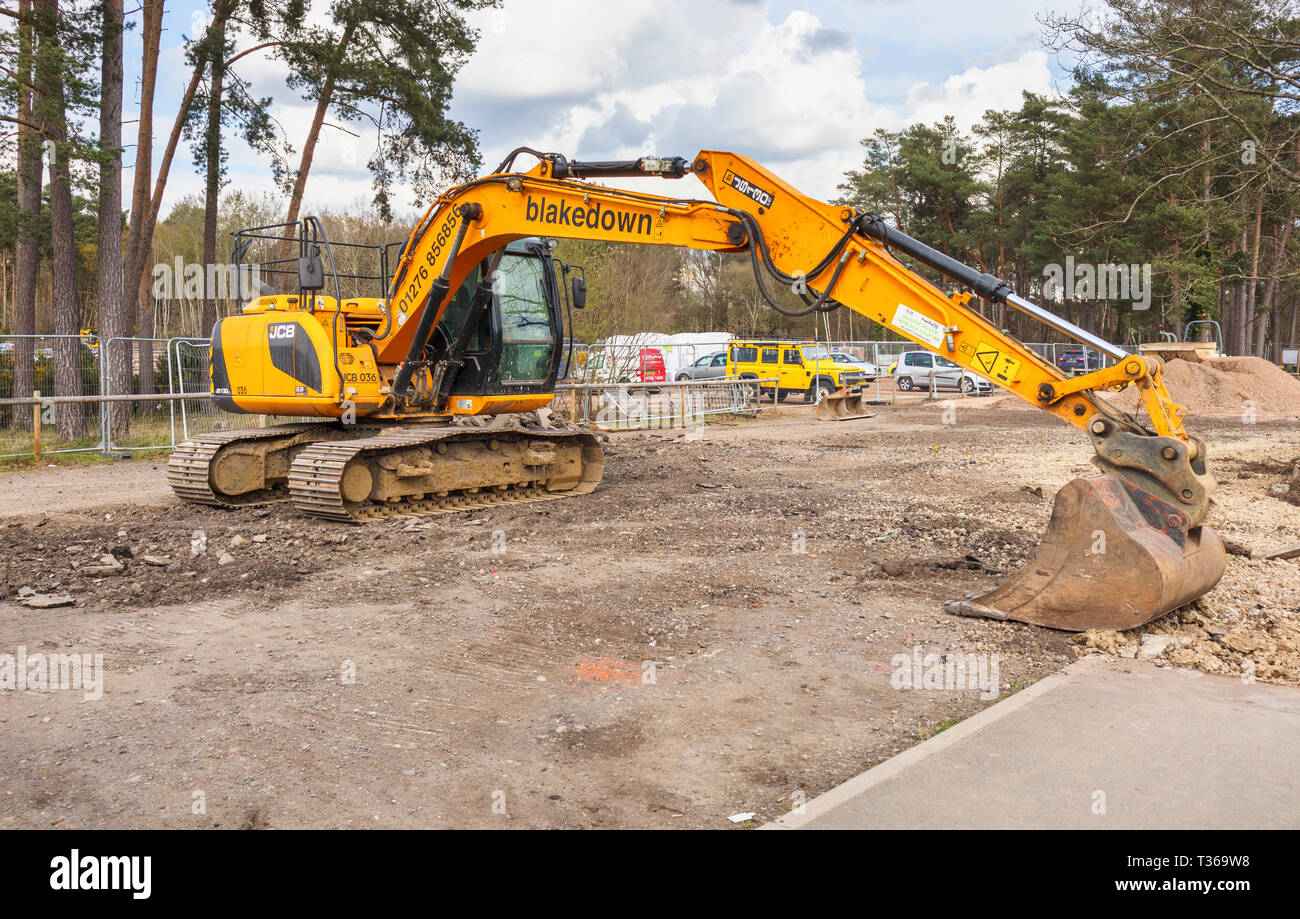 Gelb Caterpillar verfolgt JCB JS 130 LC schwerem Bagger Raupenbagger mit Schaufel Schaufel an der RHS Gärten, Wisley, Surrey, Großbritannien Stockfoto