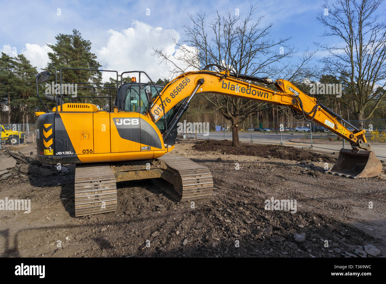 Gelb Caterpillar verfolgt JCB JS 130 LC schwerem Bagger Raupenbagger mit Schaufel Schaufel an der RHS Gärten, Wisley, Surrey, Großbritannien Stockfoto