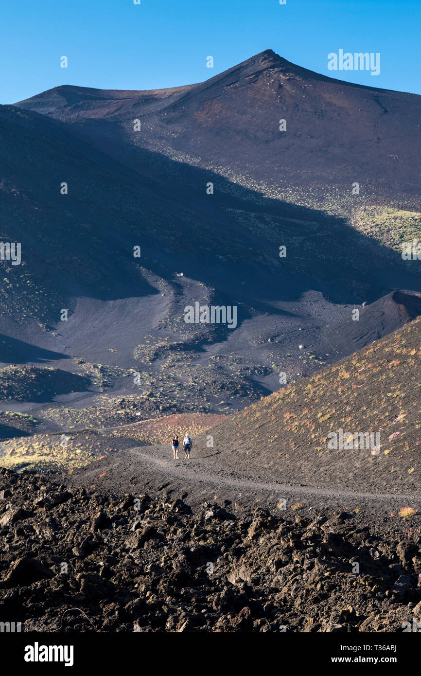 Touristen zu Fuß über die Lava Feld durch Vulkanausbruch des Ätna aktiver stratovulkan in Taormina, Sizilien, Italien Stockfoto