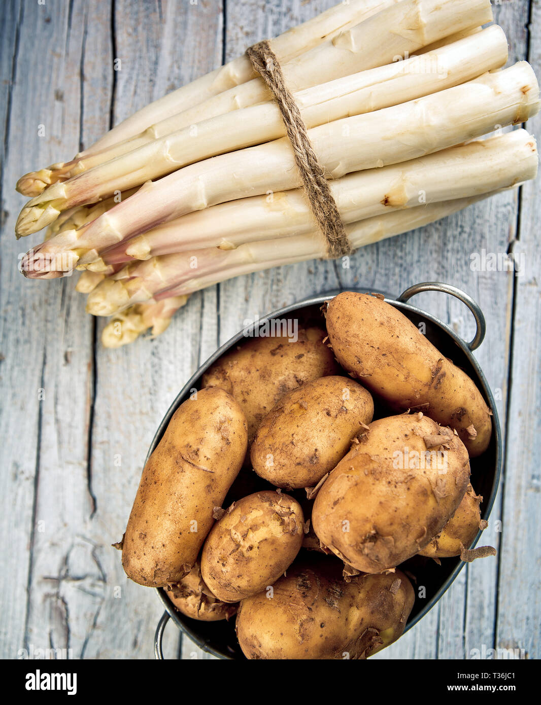 Bündel von frischem ungeschälten weißen Spargel und Kartoffeln Stockfoto