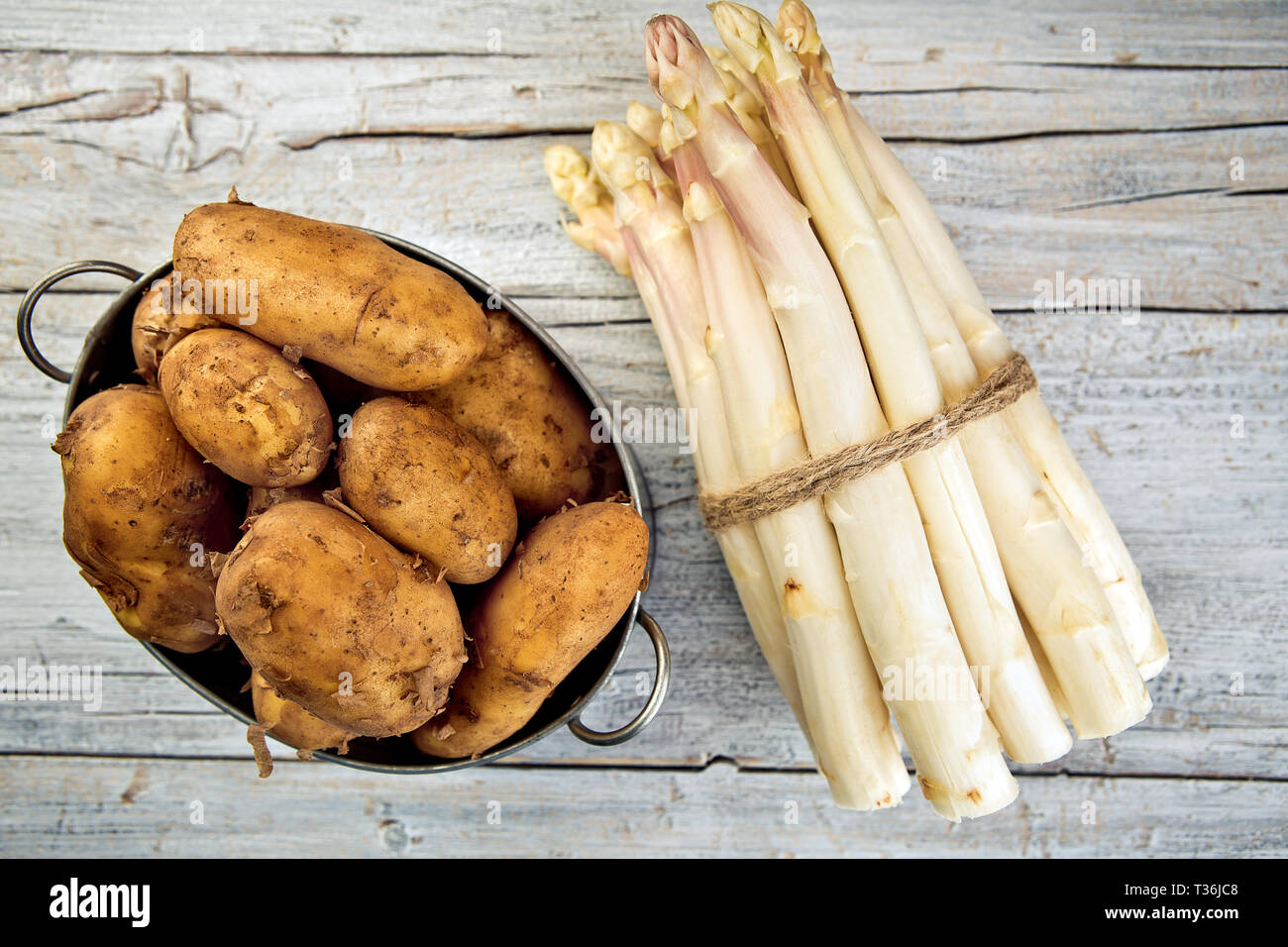 Bündel von frischem ungeschälten weißen Spargel und Kartoffeln Stockfoto