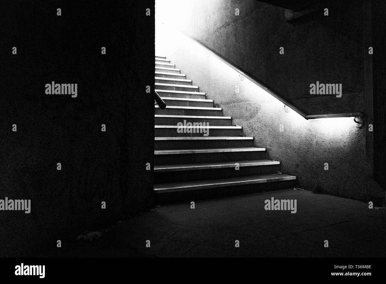 Dunkle Treppe mit Licht am oberen Ende der Treppe Stockfoto