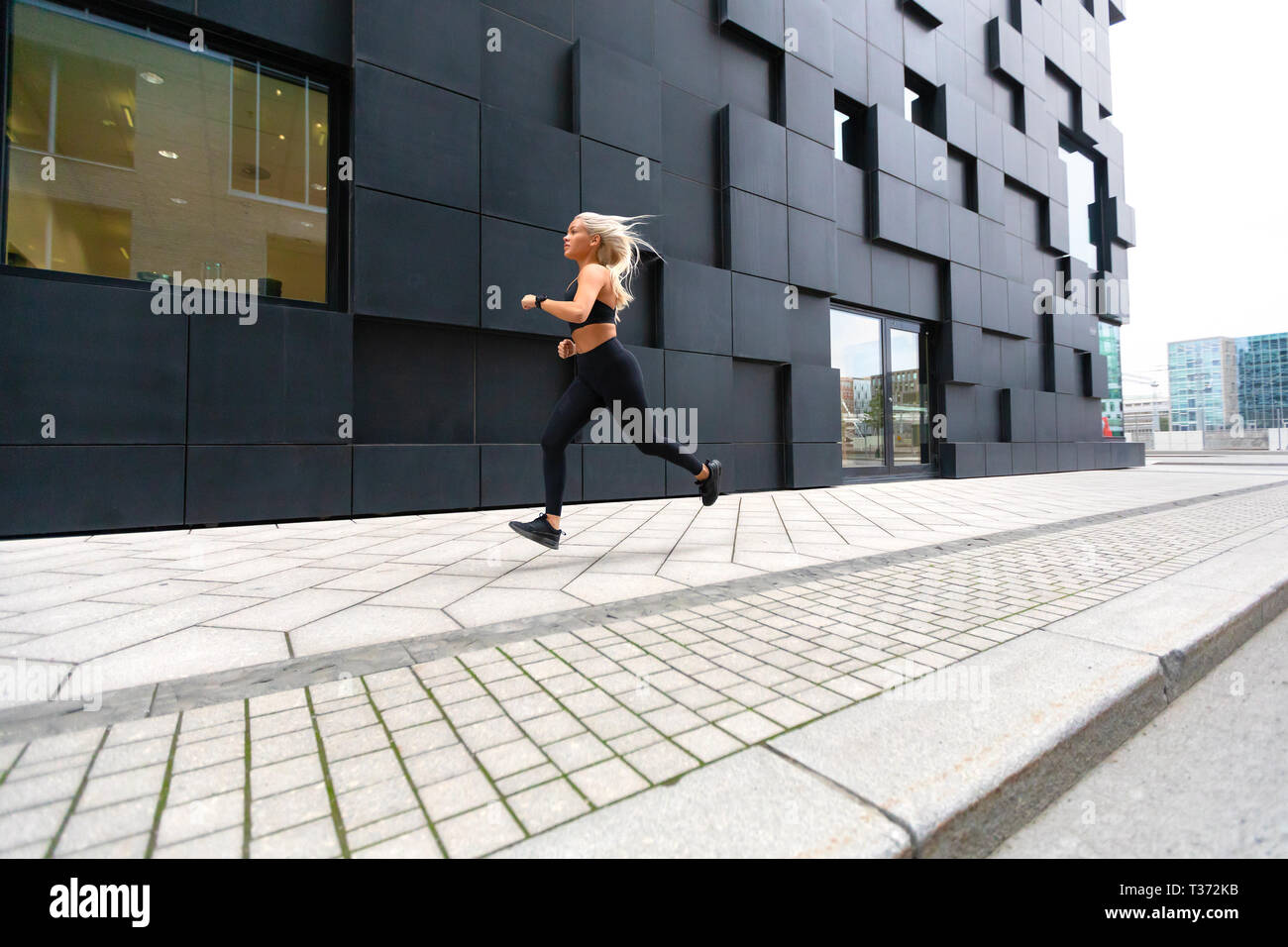 Schnell laufend junge Frau Sport tragen oben in der modernen Stadt Umgebung Stockfoto