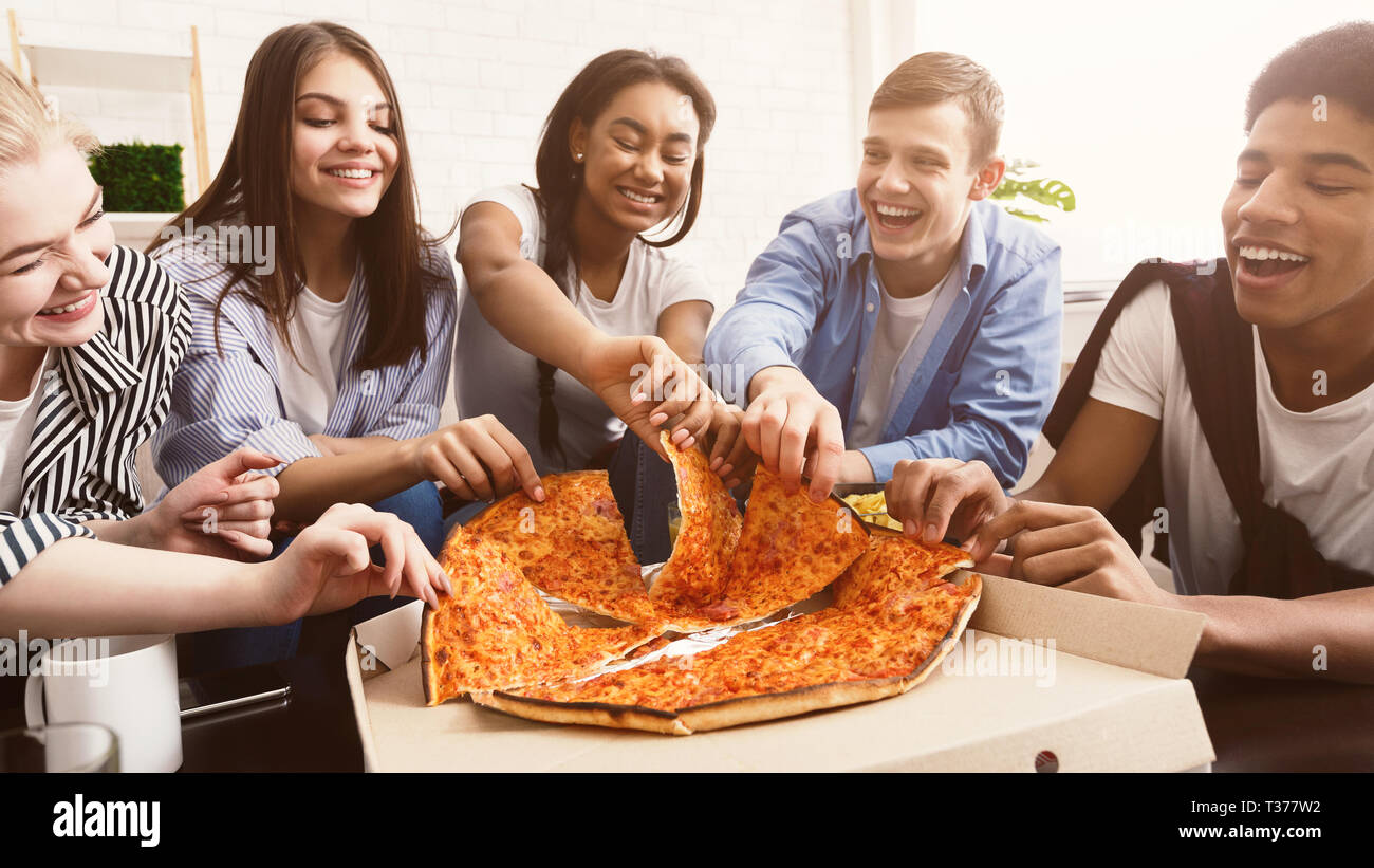 Zeit für einen Snack. Gerne Studenten essen Pizza und chatten Stockfoto