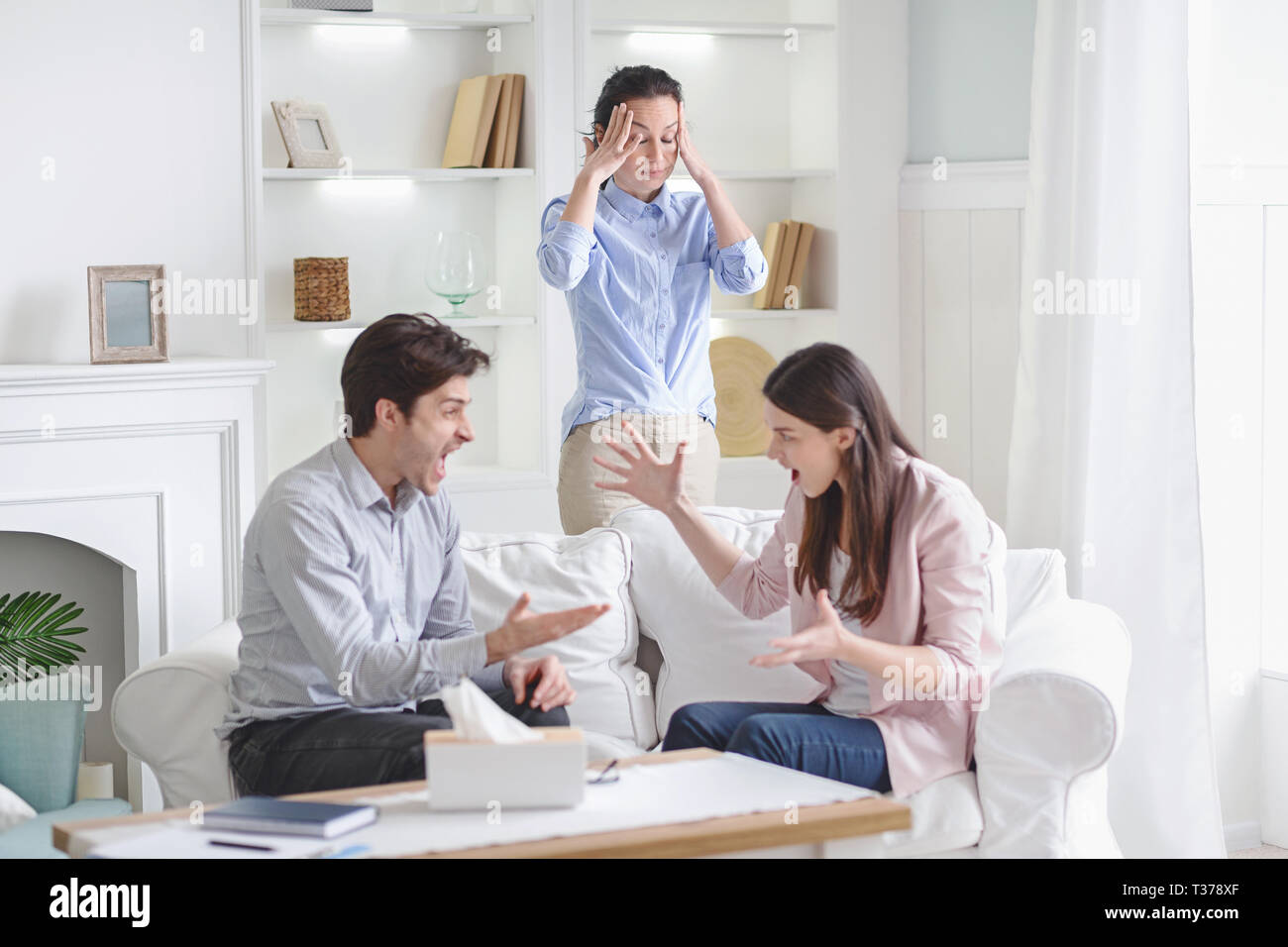 Wütend, aggressiv Paare streiten, schreien und sich gegenseitig die Schuld für die Probleme in der therapiesitzung, Familie Advisor in Schockiert Stockfoto