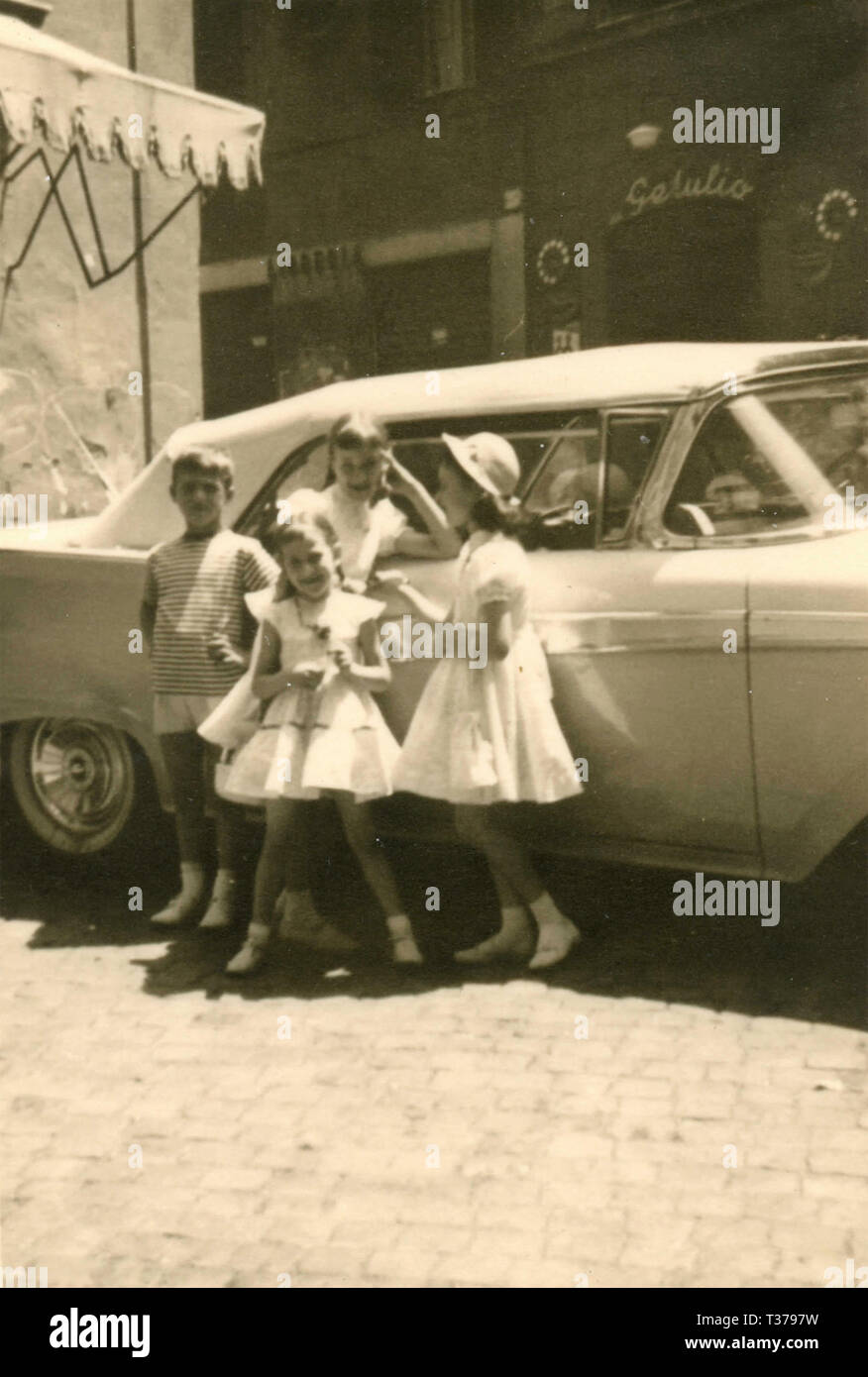 Kinder rund um ein Auto, 1950er Jahre Stockfoto