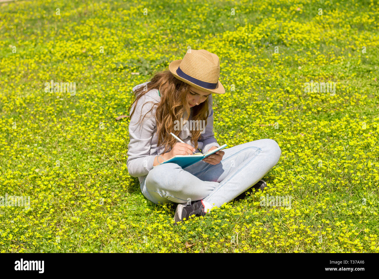 Cute Teen Girl ein Buch auf der grünen Wiese Stockfoto