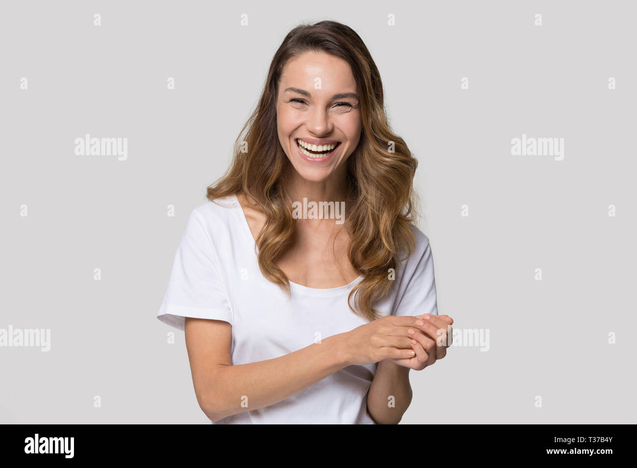 Frau Suchen an Kamera lachend fühlt sich glücklich Studio shot Stockfoto