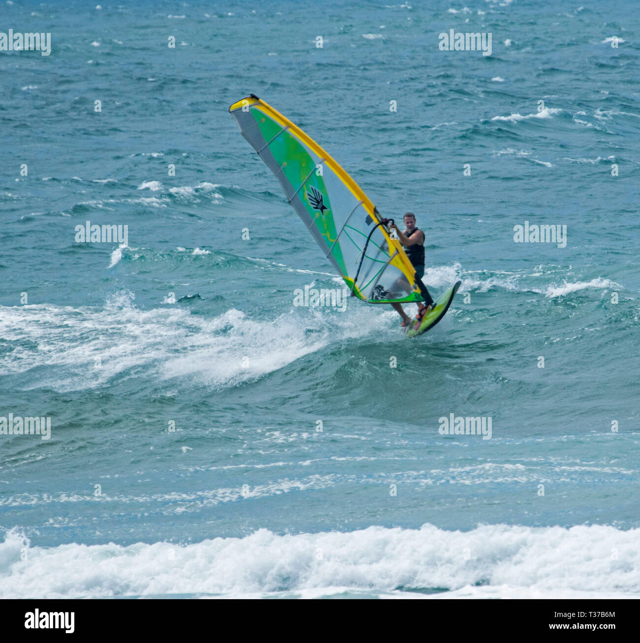 Wind surfer reiten Wellen auf blauen Pazifischen Ozean vor der Küste von Deepwater National Park in Queensland, Australien Stockfoto