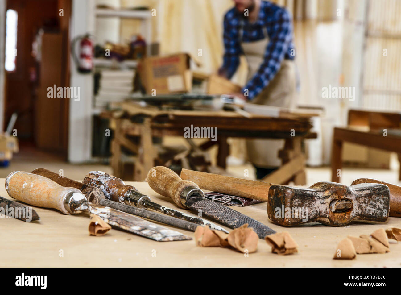 Tischler arbeiten mit Hammer und Meißel auf Holz Tisch. Workshop Hintergrund. Stockfoto