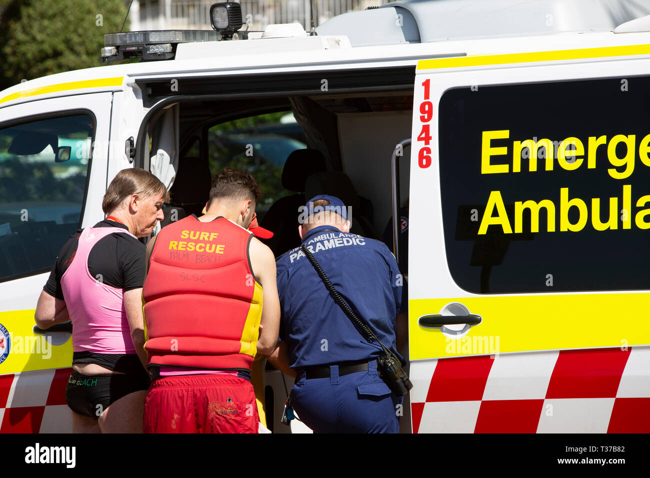 Surf rescue Freiwilliger und Sanitäter besuchen, um in der Nähe von ertrunken Mann im Palm Beach, wie er in den Krankenwagen, Sydney, Australien Stockfoto