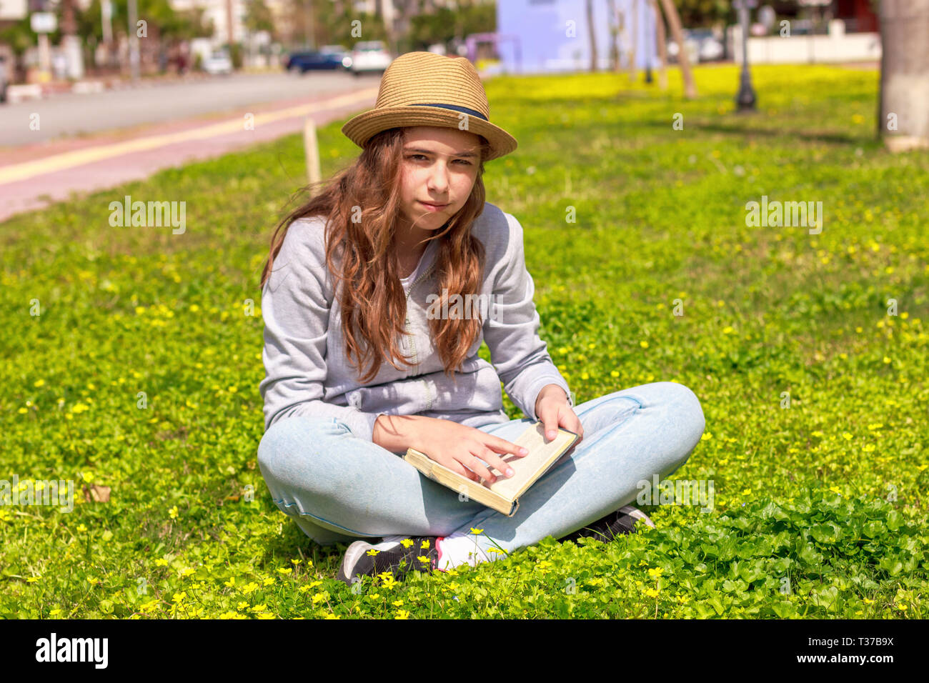Cute Teen Girl ein Buch auf der grünen Wiese Stockfoto