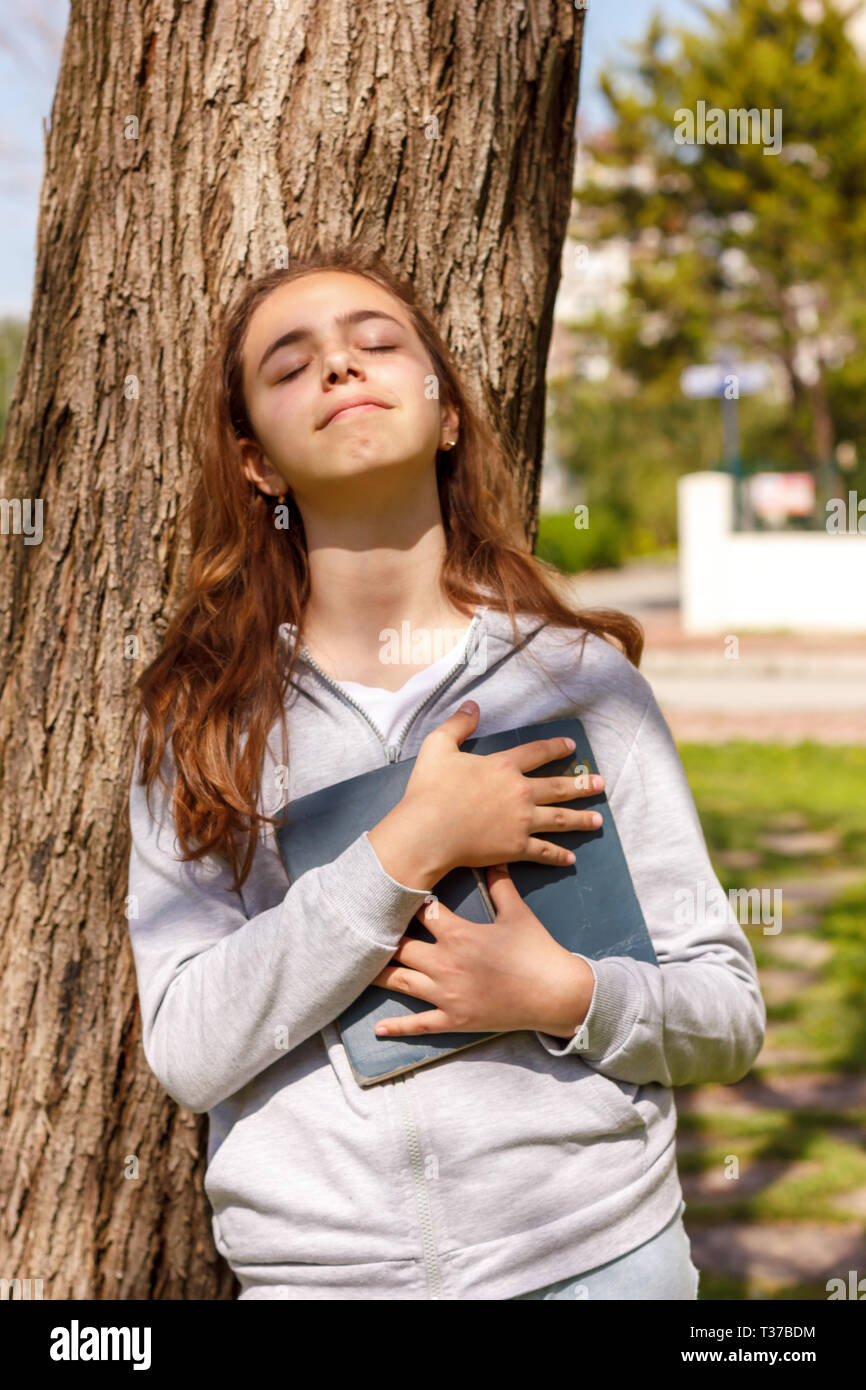 Cute teen Mädchen träumt von der Liebe in der Nähe von Pine Tree Stockfoto