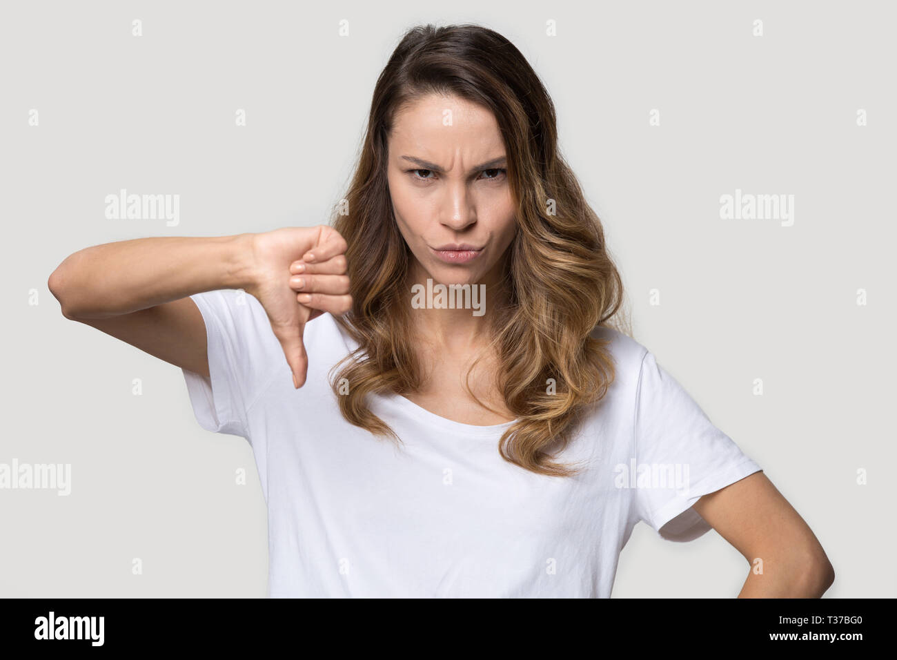 Wütende Frau Daumen nach unten Missbilligung Geste studio Shot Stockfoto