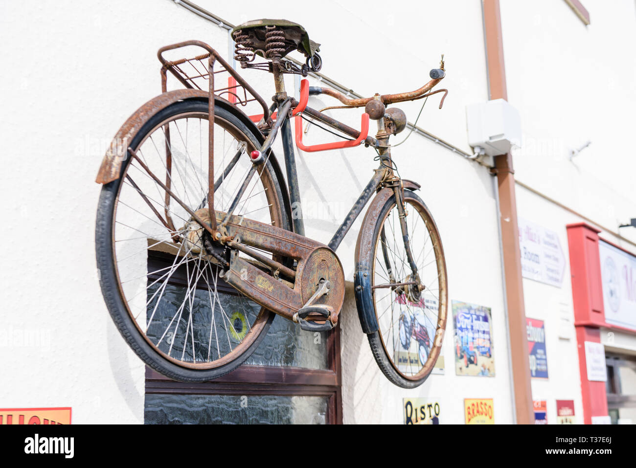 Ein Fahrrad- und ein altmodisches Metall werbeschilder an der Wand außerhalb eines Irish Shop. Stockfoto