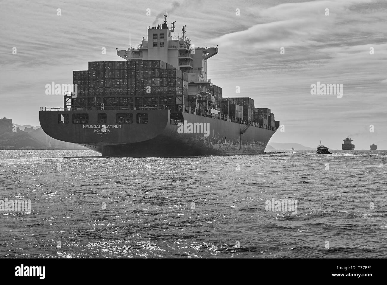Moody Schwarz-Weiß-Foto Des Riesigen Containerschiffs Hyundai Platinum Im Geschäftigen East Lamma Channel, Hongkong, China Stockfoto