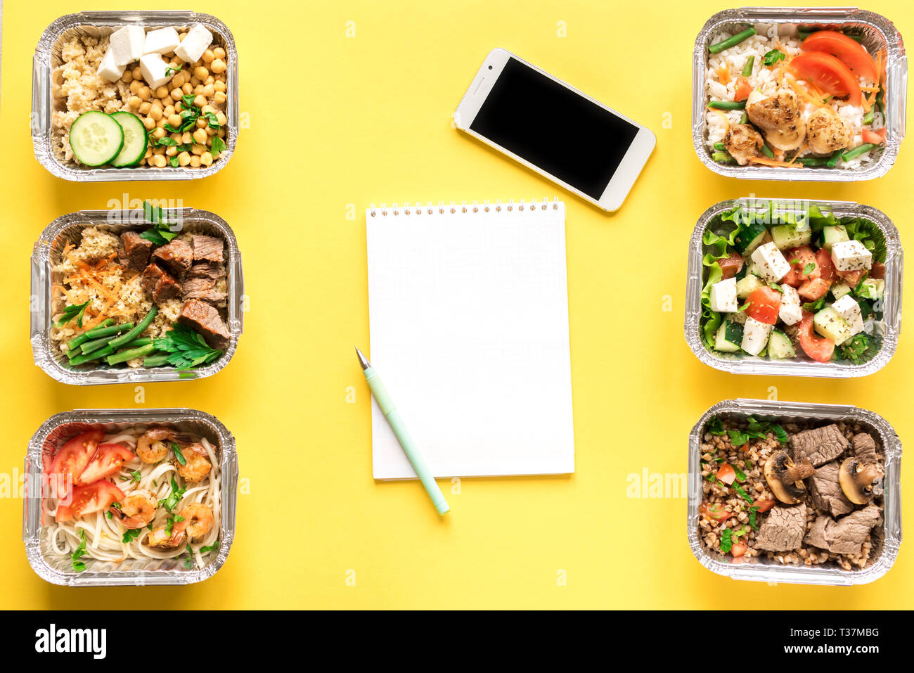 Gesunde Mahlzeiten in Folie Boxen und Smartphone auf Gelb, Ansicht von oben, flach. Gesundes Essen Lieferung Konzept. Fitness Ernährung Ernährung, kopieren. Stockfoto
