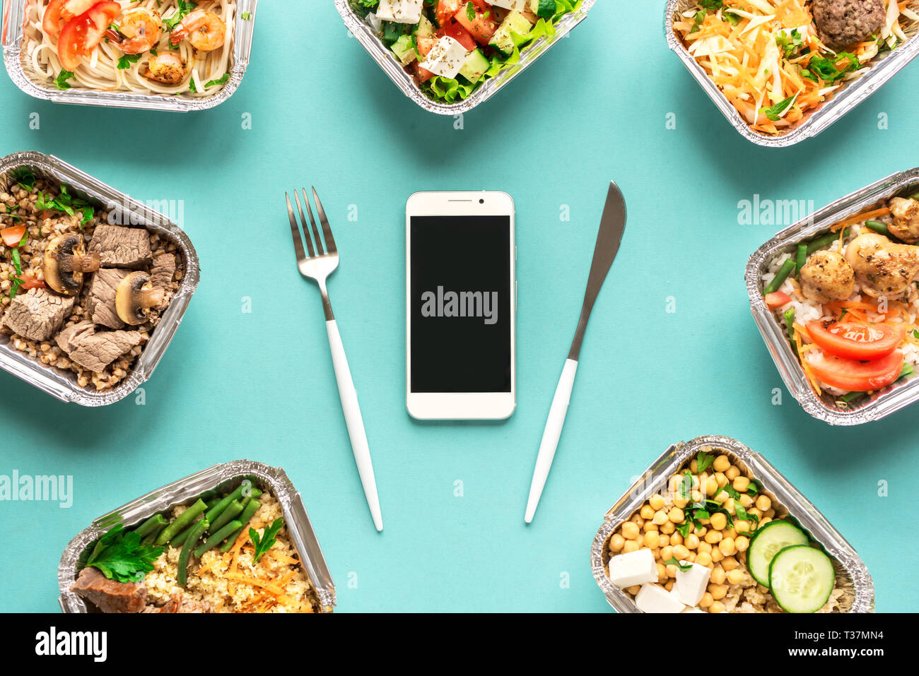 Täglichen Mahlzeiten in Folie Boxen und Smartphone, Ansicht von oben, flach. Gesundes Essen Lieferung Konzept. Fitness Ernährung für Ernährung. Stockfoto
