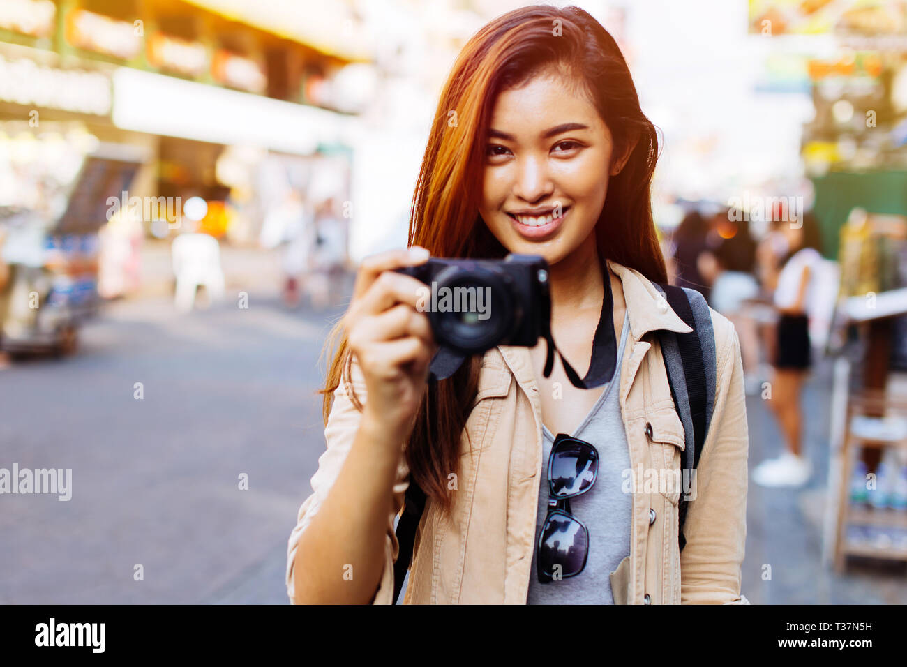Junge asiatische Frau touristische Frau mit Smile Holding eine Kamera und Fotos in Bangkok, Thailand Reisen in Südostasien Stockfoto