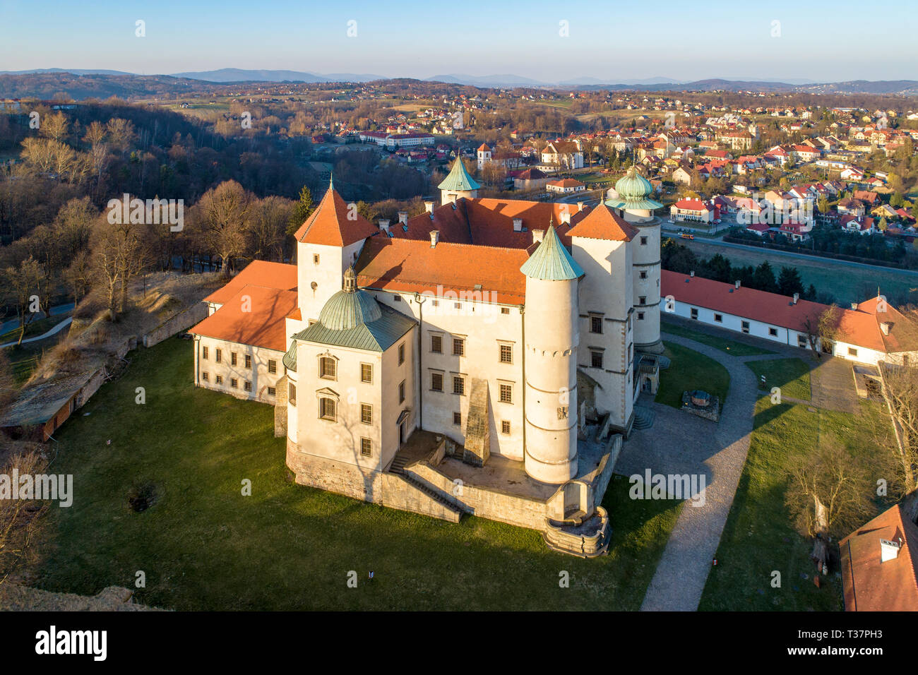 Polen. Renaissance, Barock Schloss mit einer Kapelle auf dem Hügel in Nowy WiÅ' Nicz. Die derzeit vom polnischen Staat gehört. Luftaufnahme im Frühjahr. Sunrise Stockfoto