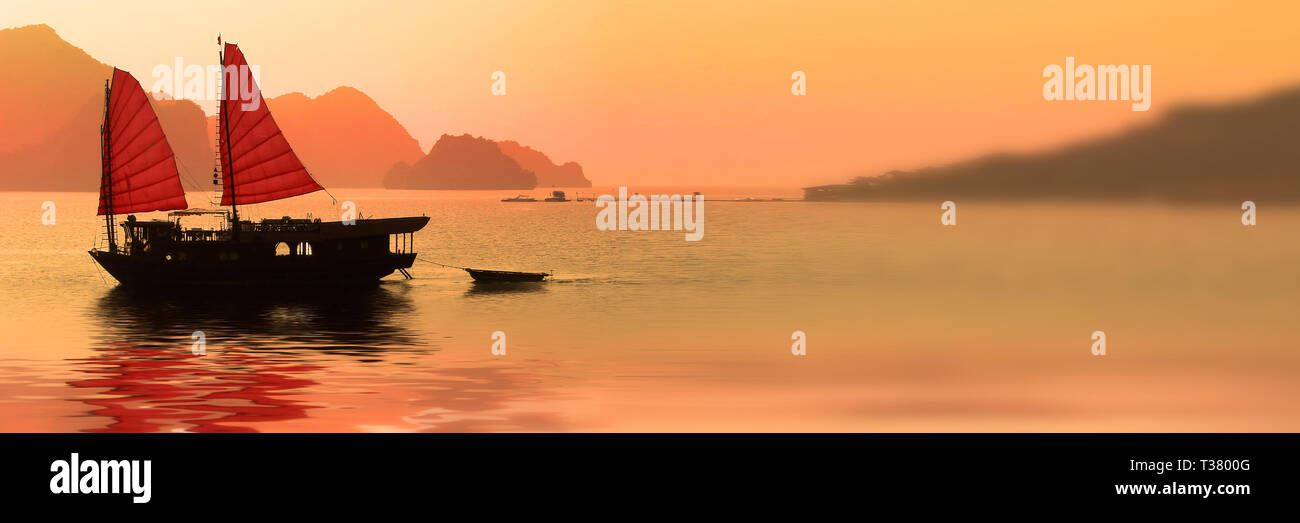 Junk-Boot bei Sonnenuntergang in der Halong Bay, Vietnam Stockfoto