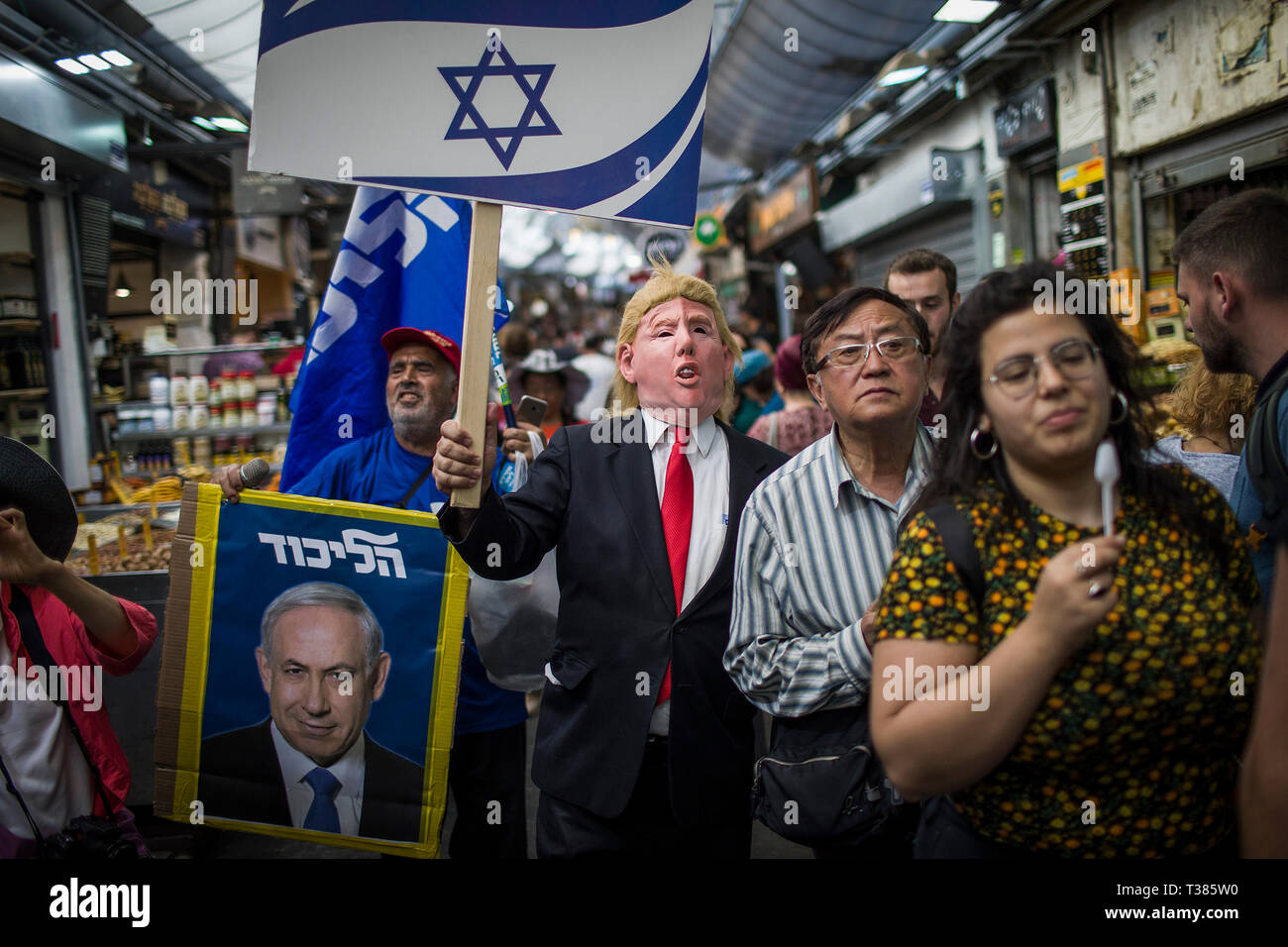 Jerusalem, Naher Osten. 7 Apr, 2019. Ein Anhänger des Likud Partei, ist gekleidet, wie US-Präsident Donald Trump gesehen, während ein anderer hält eine Abbildung der israelischen Premierminister Benjamin Netanjahu, wie sie in der Mahane Yehuda Market entfernt, vor der israelischen Parlamentswahlen, die am 09. April statt. Credit: Ilia Yefimovich/dpa/Alamy leben Nachrichten Stockfoto
