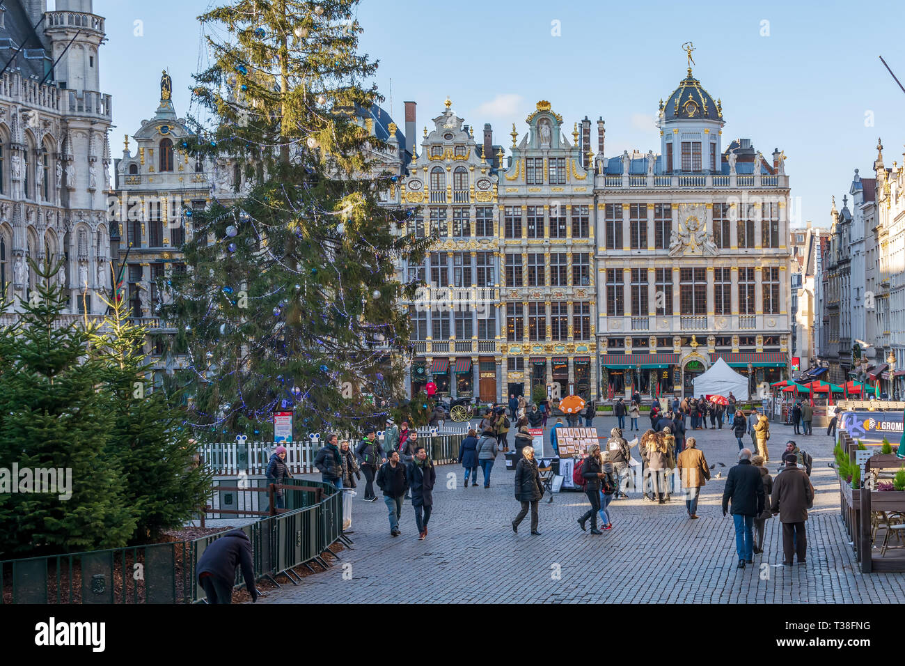 Touristen auf dem berühmten Grand Place in Brüssel, mit reichen skulpturalen dekoriert Guild Häuserfassaden und Weihnachtsbäumen. Stockfoto