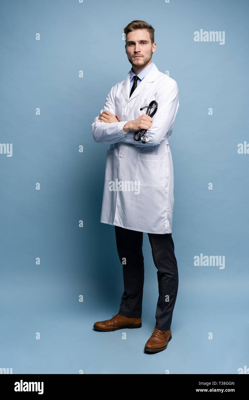 Volle Länge junge Arzt auf blauem Hintergrund. Stockfoto